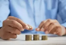 A man counts coins on a wooden table