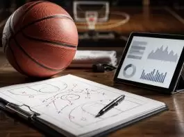 Basketball, tactic sheet and tablet with charts arranged on a court-side desk