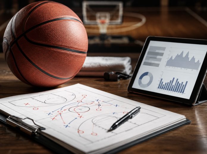 Basketball, tactic sheet and tablet with charts arranged on a court-side desk